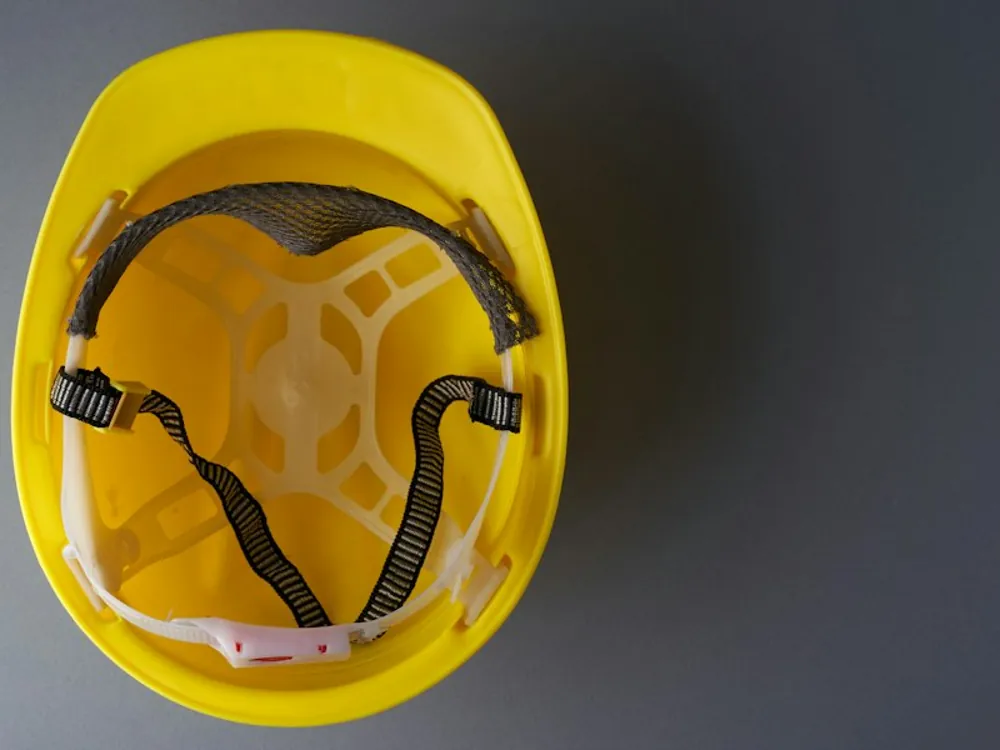 Capacete de segurança amarelo sobre fundo cinza